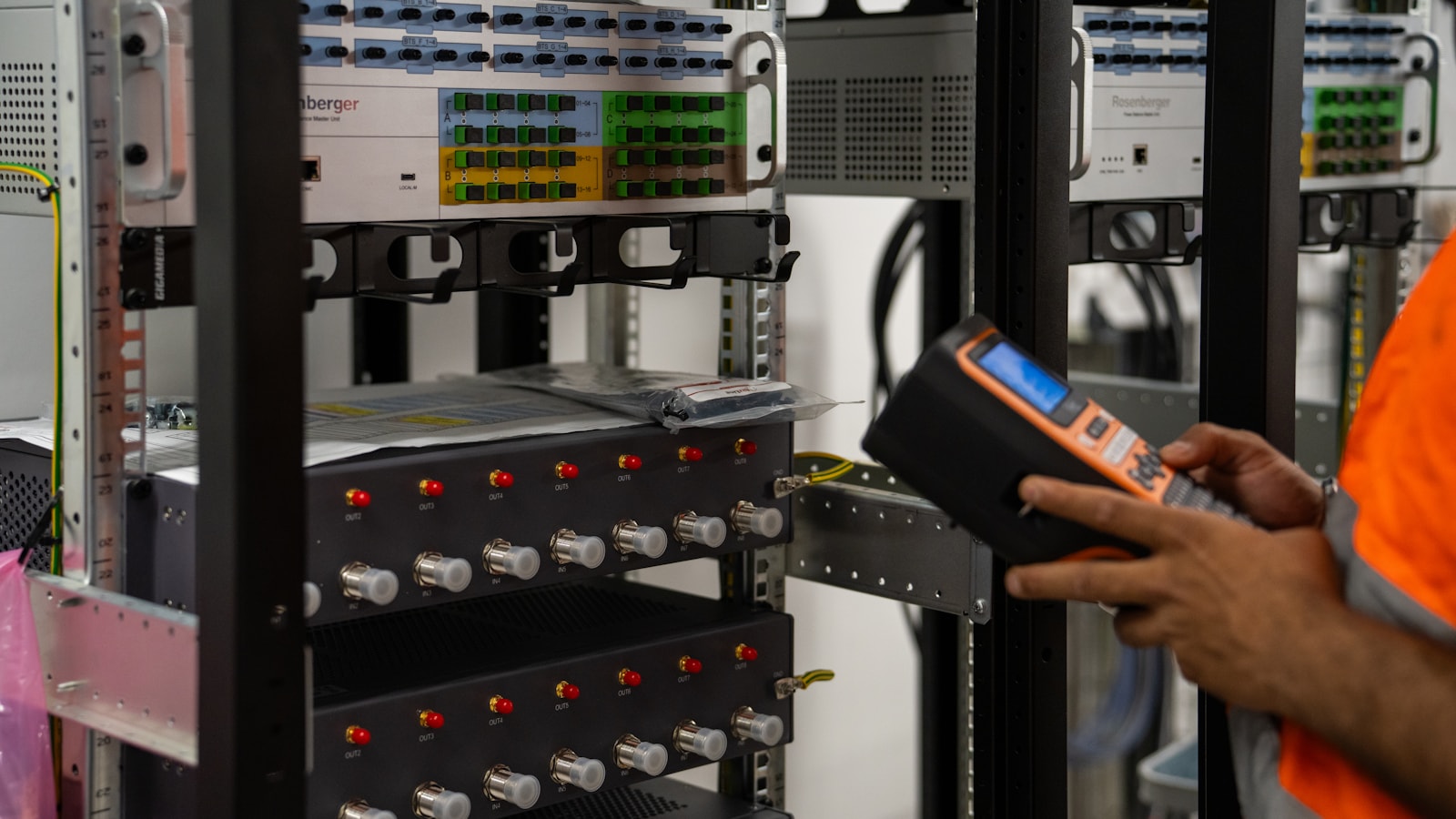 Technician inspecting server rack equipment with a diagnostic tool